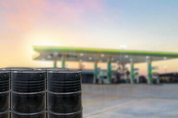 Black oil barrels against with gas station blurred background