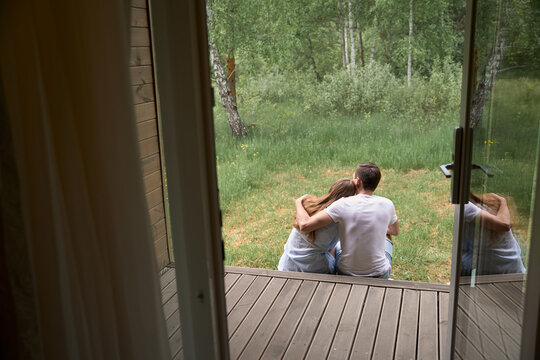 Happy couple sitting on edge of terrace
