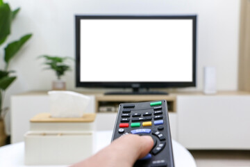 Streaming and watching TV, movie night, first-person view, pressing remote control, white blank TV screen blurred in background. Clean and modern living room interior.