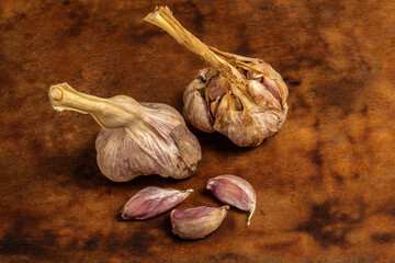 Still life of garlic on rustic wooden background: fresh and natural ingredients for traditional cuisine.