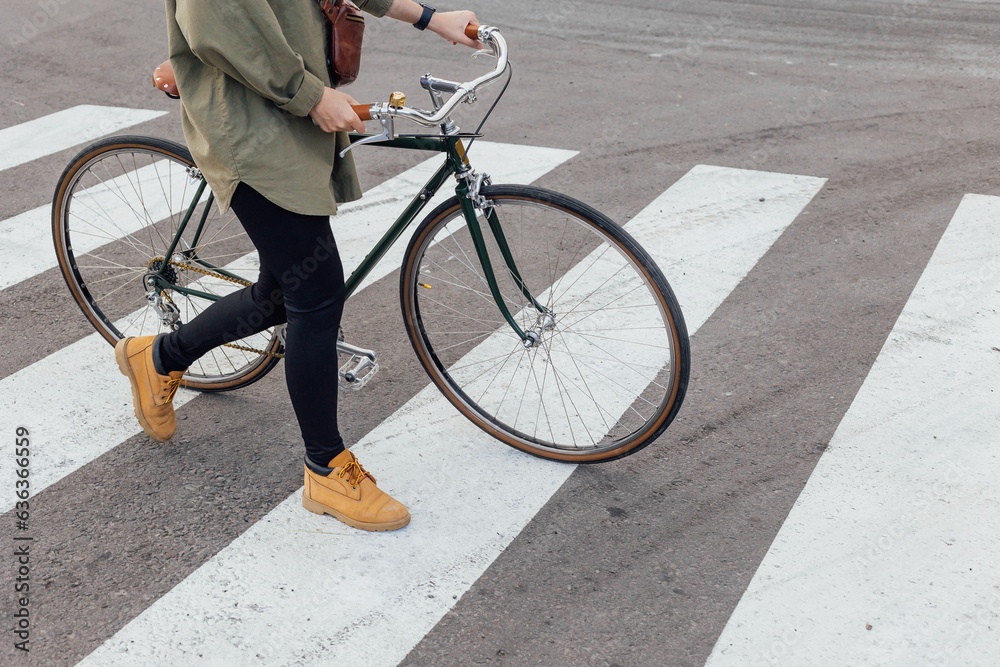 Wall mural lovely woman goes the road with bicycle on crosswalk