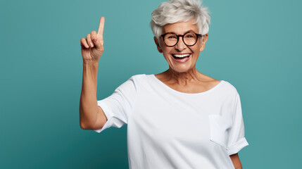 Senior woman wearing white white T-shirt pointing with hand and finger to the side looking at the camera. - obrazy, fototapety, plakaty