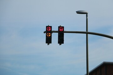 close-up of a double traffic light on the right is red for straight ahead and on the left the traffic light changes to green with the yellow light