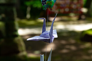A paper crane swaying in the wind at the traditional street close up