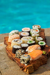 assorted sushi on a board near the pool