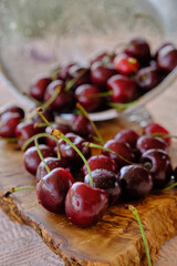 ripe cherries scattered on a wooden board
