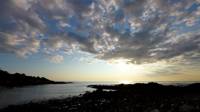 Atlantic ocean wide angle sunrise along rocky rugged coastline with low sea level tide
