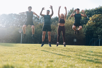 healthy sporty family outdoors jumping happily on grass