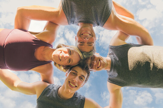 bottom view of sporty family smiling and happy embraced in circle - healthy lifestyle in every age strong team concept