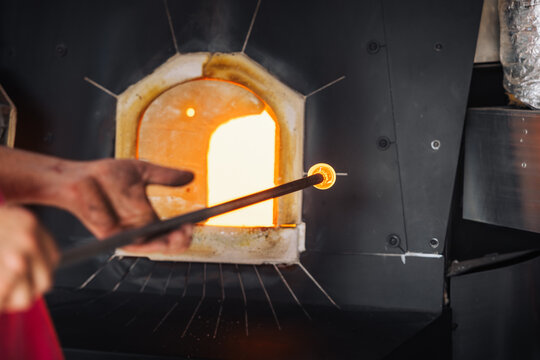 Glassblower crafting a Christmas bauble, from the heat of the oven to shaping it. Workshop based in France.