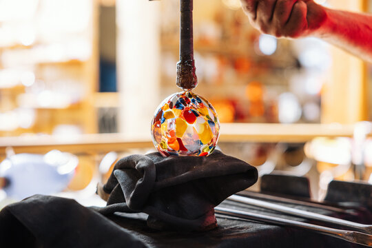 Glassblower crafting a Christmas bauble, from the heat of the oven to shaping it. Workshop based in France.
