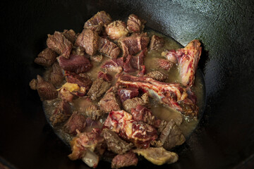 a hot oil and raw meat in a pan cooking