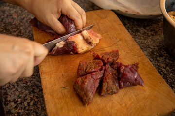 cutting the meat with a knife in a chopping board