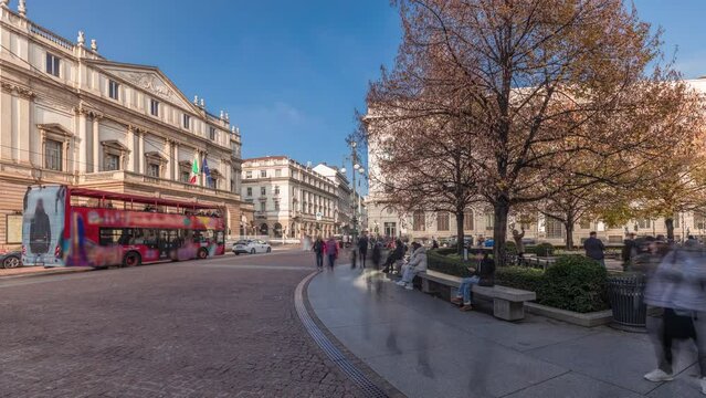 Panorama showing theater La Scala timelapse and a small park opposite to historic building with a monument to Leonardo da Vinci and his students. People walking around and sitting on a bench