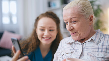 A woman caregiver calls the family of the senior woman in the nursing home to provide comfort and...