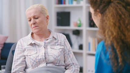 Lonely senior woman feeling sadness, refusing to talk and take medication
