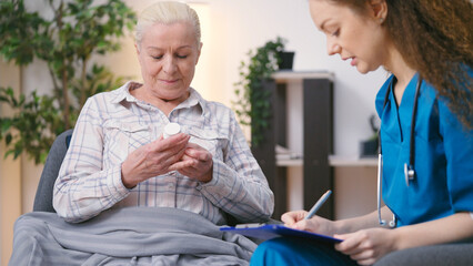 Fototapeta General practitioner prescribing pills to senior woman, personal home care obraz