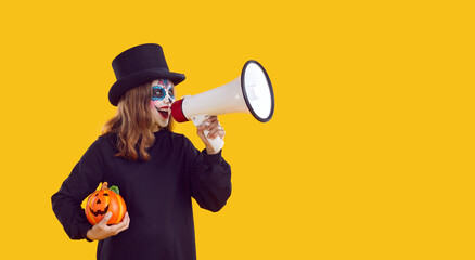 Happy child girl in spooky Halloween costume standing isolated on yellow color copyspace background...