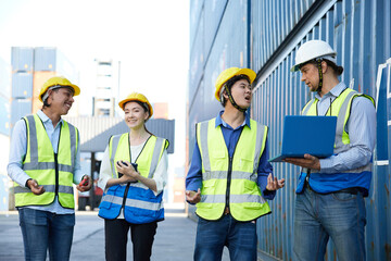 factory workers or engineers meeting and working on laptop computer in containers warehouse storage