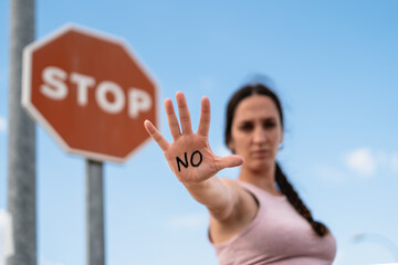 firm woman expressing the action of enough with her hand, no or stop, no violence, no permission