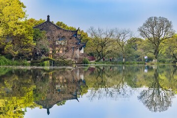 Fototapeta na wymiar Scenic view of a temple near a tranquil lake in a park in Hangzhou, China