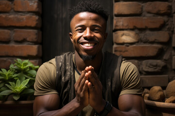 A South African man leans against a brick wall eyes closed and palms open as he relishes in a few calming deep breaths of fresh air.