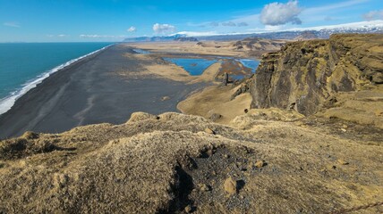 Tranquil beach scene featuring golden sand, lush brown grass