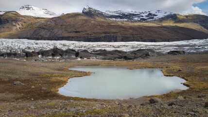 a body of water with a very big mountain in the background