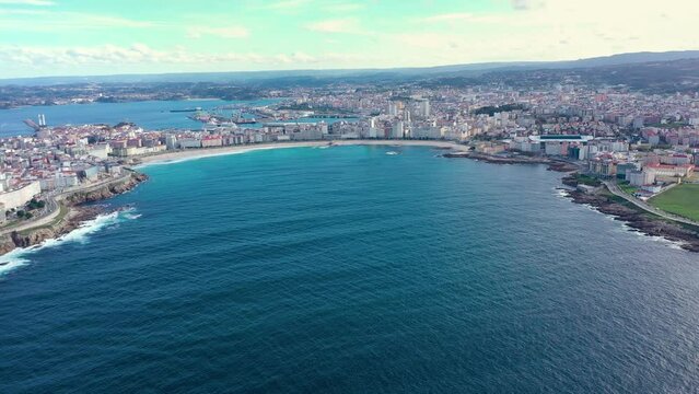 Aerial drone view of A Coruna, Galicia, Spain. Drone forward above de bay. In front are the two main beaches of A Coruna, Riazor and Orz&aacute;n Beach. In background is the port area of the city. Travel.