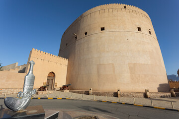 A picture of Nizwa, where the ancient Nizwa Fort appears, and the Omani dagger, which is one of the things that Nizwa is famous for