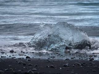 Ice melting off a rock at the Diamond beach by the ocean