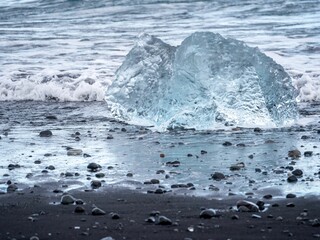 Ice melting off a rock at the Diamond beach by the ocean