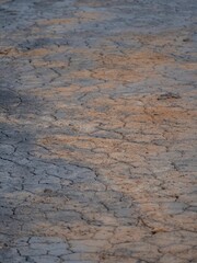 Close-up shot of an earthen ground composed of small grey rocks and muddy soil