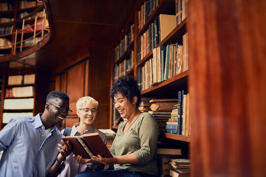 Young and diverse group of students studying and talking together in the library