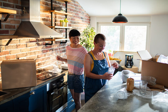 Young female lesbian couple decorating and moving in their new home apartment
