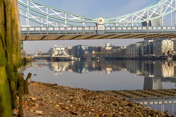 a long bridge over a river in the city with many buildings