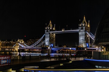 Iconic Tower Bridge in London, England, illuminated in a soft blue hue