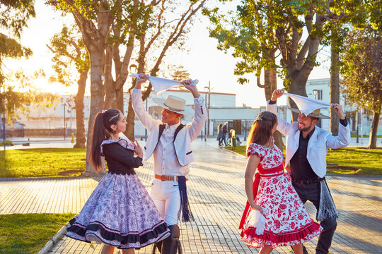 retrato dos parejas latinas bailando cueca vestidos con el traje tradicional de huaso