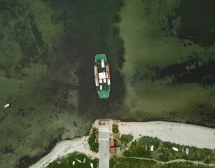 Aerial top view of a Roll-on and roll-off (RORO) ship carrying vehicles near the shore