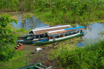 two boats on a body of water with trees behind them