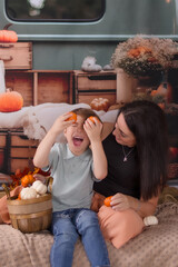 family posing for a autumn photo in the back of a pickup truck  playing with pumpkins 