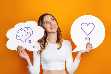 iq eq concept. girl holding poster with hand drawing a brain and heart