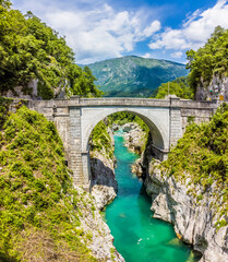 Fototapeta na wymiar A view from the Soca river gorge towards the Napoleon Bridge near Kobarid, Slovenia in summertime
