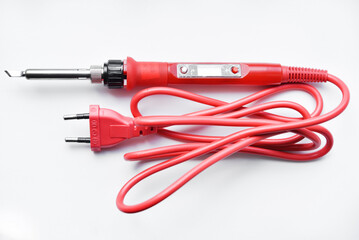Red soldering iron on a white background. A tool for repairing electronics.