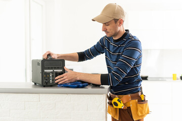 a male craftsman repairs a portable charging station