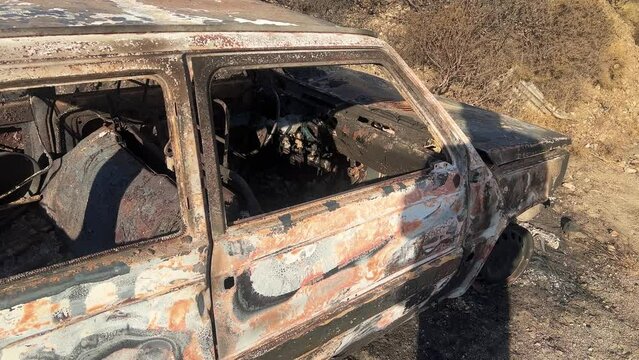 Wracked burned car on a dry ground on a sunny day
