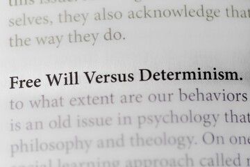 Close-up of the philosophical thought of Free Will Versus Determinism, on paper background
