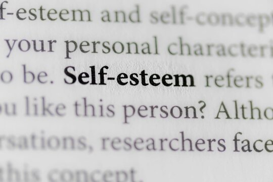 Open book with the word 'Self-Esteem' written on the page in bold, black lettering