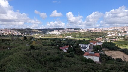 Portugal, suburbs of Lisbon, forest, house, field, city skyline, sky and clouds