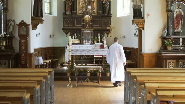 The Holy Father is preparing for Mass. The priest in the church in front of the altar is preparing for the wedding, baptism.
